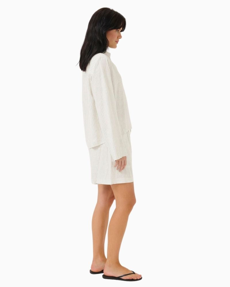Side of Casual fit summer shorts in neutral fabric styled with simple top and sandals