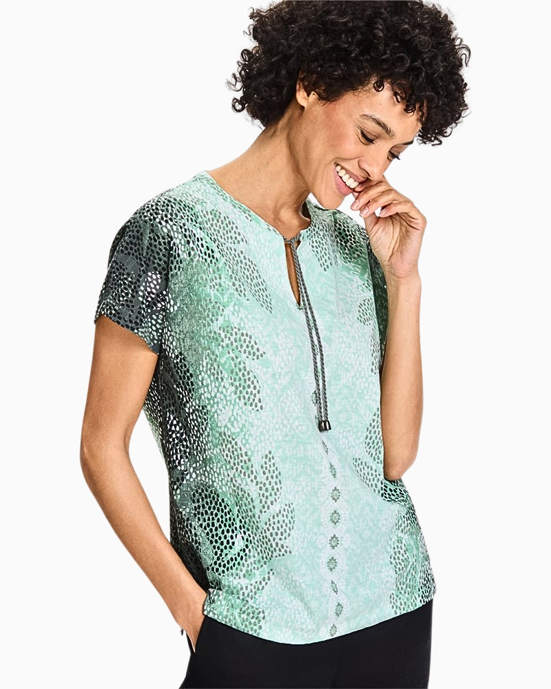 Model wearing Olsen Cosima Fit leaf print top in soft green tones