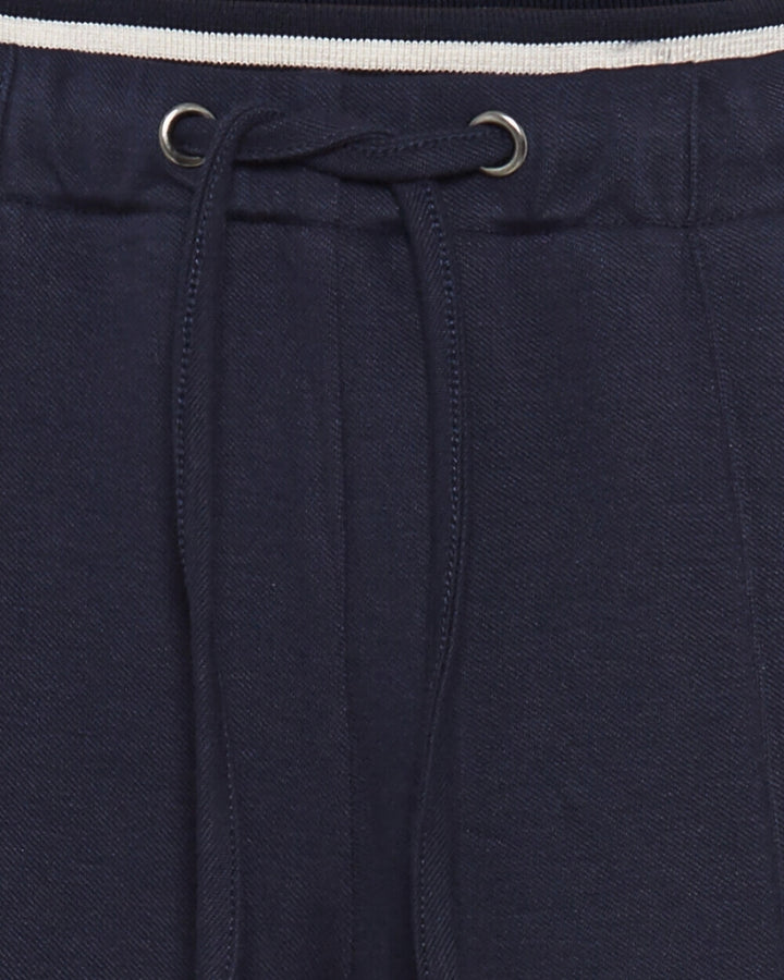 Close-up of contrast waistband and pleat stitching