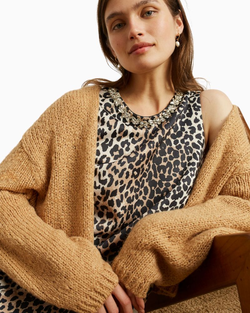 Close-up of soft scuba fabric and decorative stone detail at neckline
