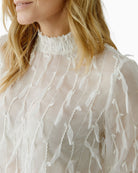 Close-up of fabric texture and neckline on Oui white blouse