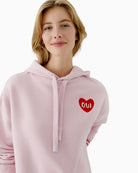 Close-up of heart logo detail on Oui hoodie in soft mauve shade