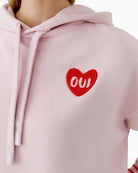 Close-up of heart logo detail on Oui hoodie in soft mauve shade