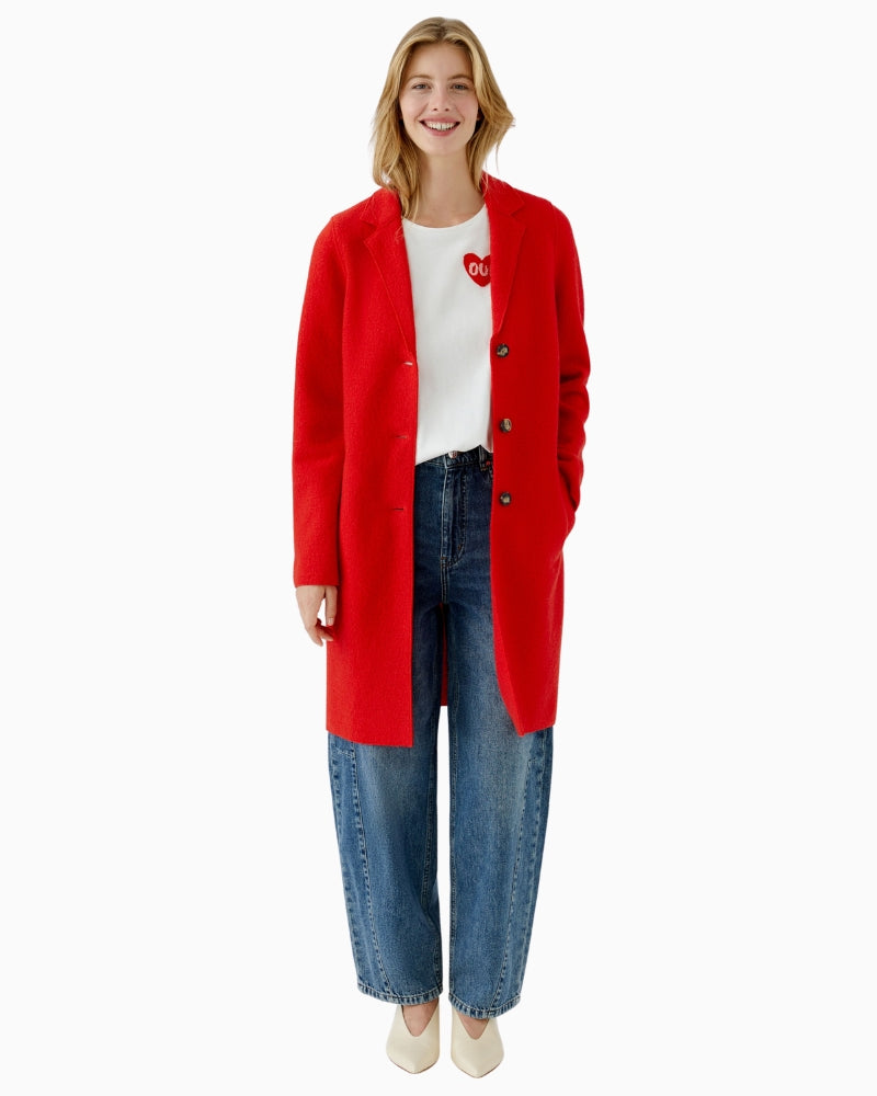 Red Oui coat styled casually over knitwear and trousers