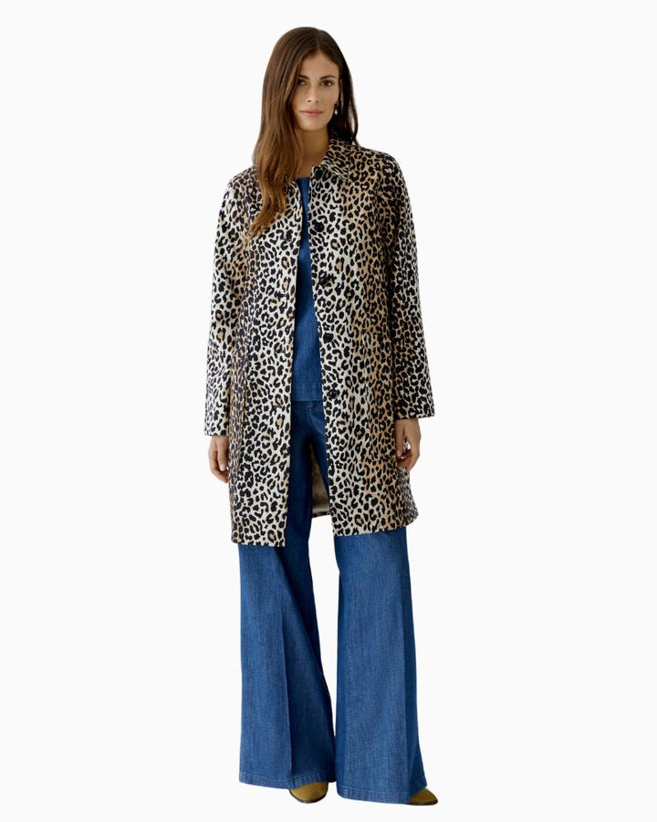 Model wearing printed Oui coat styled with black trousers and heels