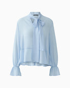 Feminine blue blouse in lightweight polyester with bow neckline