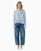 Oui blouse in soft blue styled with trousers for smart look