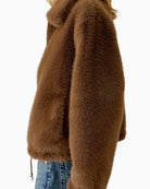 Side angle of taupe faux fur jacket with adjustable hem width