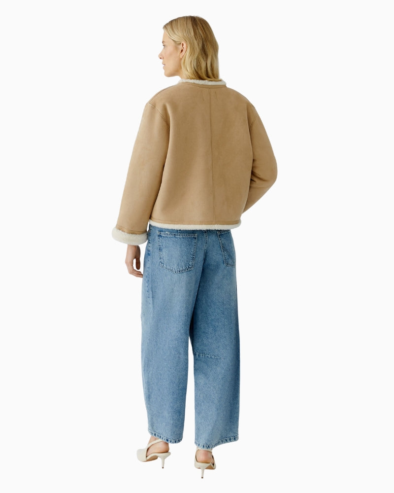 Back view of cropped camel faux leather jacket with straight cut and fold-over sleeves