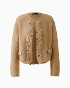 Front view of beige cropped knit jacket showing shoulder pads and trim