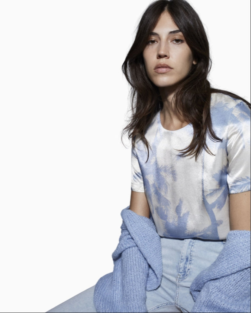 Model wearing Oui lightweight white blue satin blouse styled casually