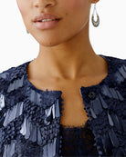 Detail of round neckline and press-button closure 