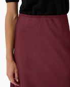 Close up of Midi skirt in Tawny Port by Part Two with glossy recycled fabric and A-line shape