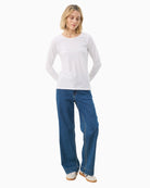 Tee laid flat displaying cut, neckline and long sleeve silhouette