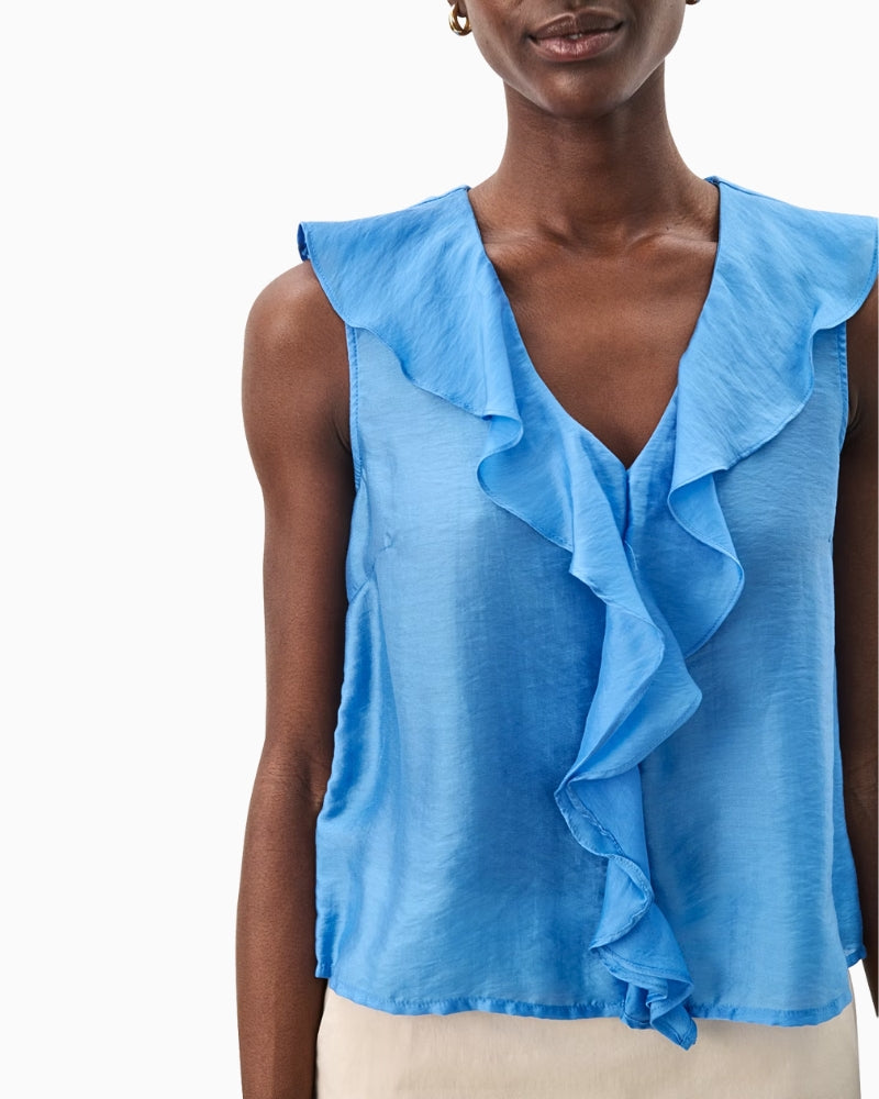 Close-up of blue sleeveless blouse with ruffled V-neckline and soft drape