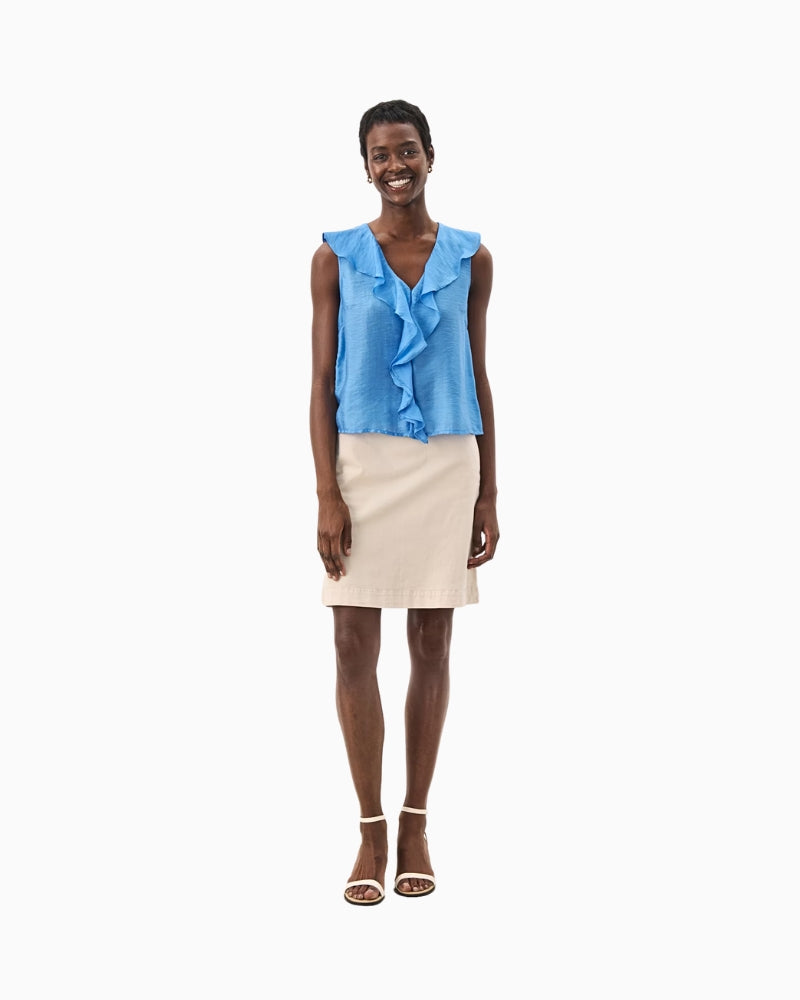 Chic summer outfit with blue ruffle-front blouse styled with cream skirt and heels