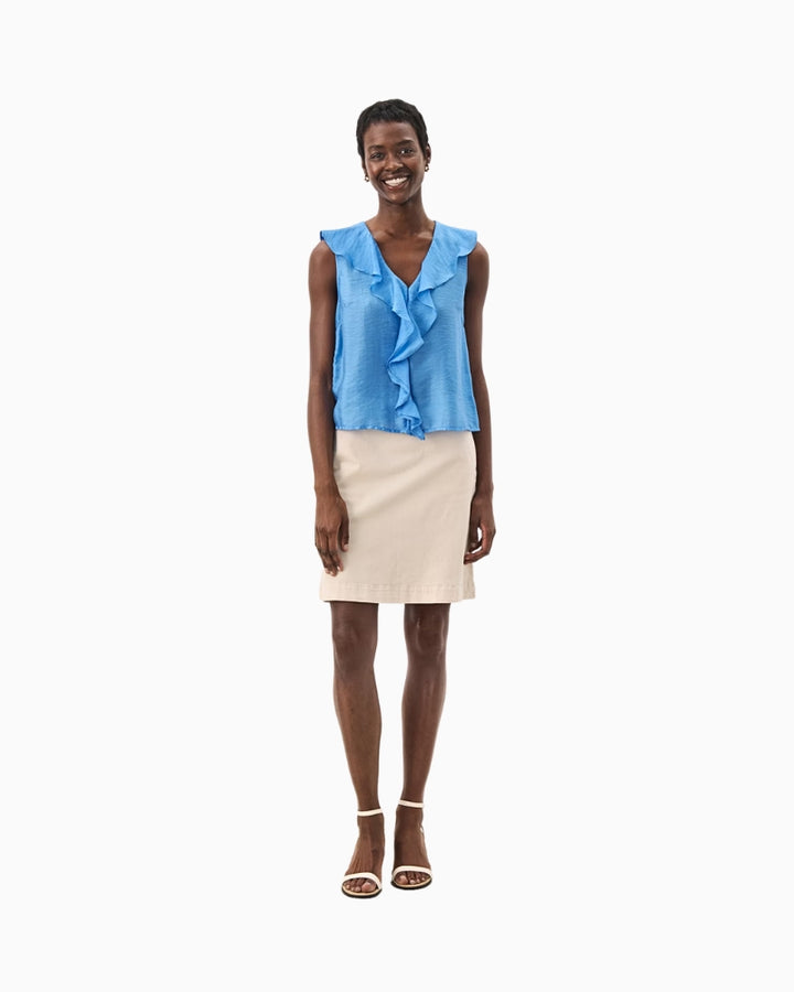 Chic summer outfit with blue ruffle-front blouse styled with cream skirt and heels