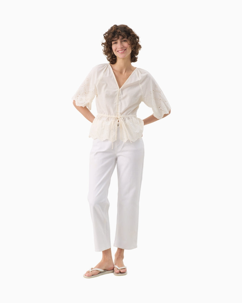Full length view of model wearing cream Part Two blouse with linen trousers