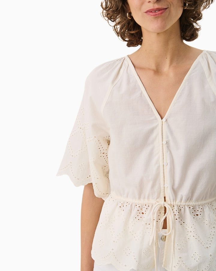 Close-up of neckline and sleeve detail on cream organic cotton Part Two blouse