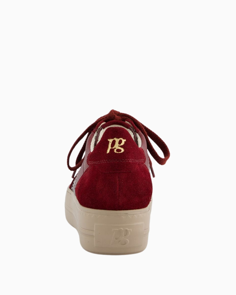 Close-up of suede and patent leather detail on red sneakers