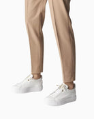 Model wearing white Paul Green trainers styled with jeans