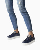 Model wearing navy trainers with casual trousers