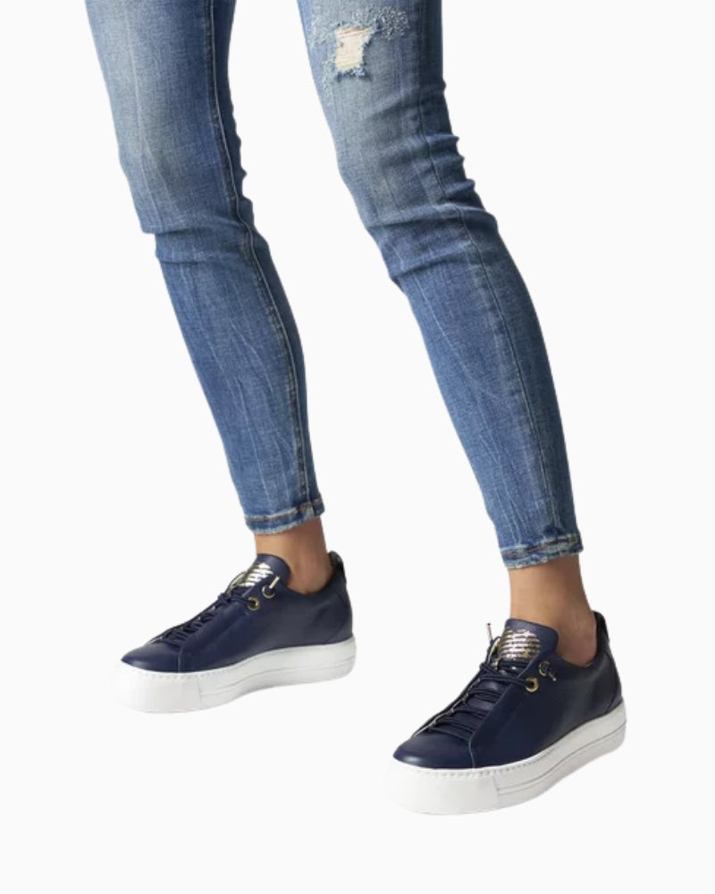 Model wearing navy trainers with casual trousers