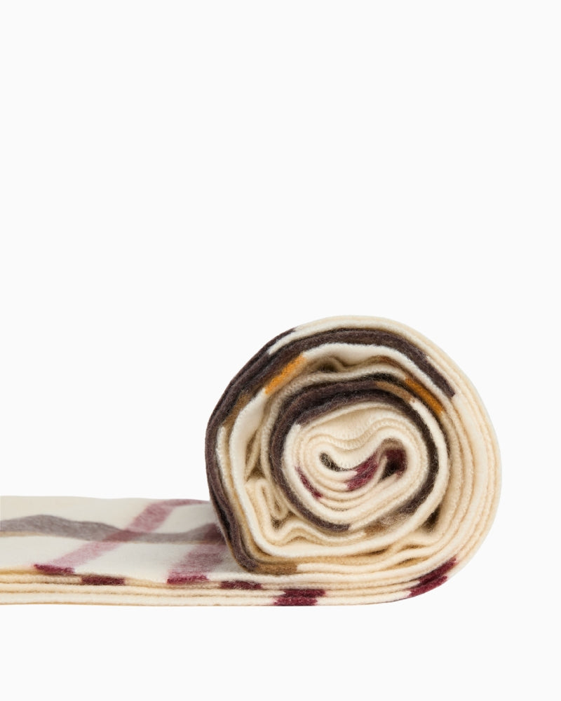 Rolled cream tartan scarf showing spiral fabric texture detail