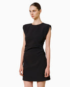 Woman wearing SPELL black mini dress, side view showing padded shoulders – Áines Boutique