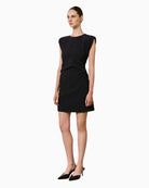 Woman wearing SPELL black mini dress with ruching, front view – Áines Boutique