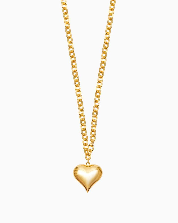 Close-up of large gold heart pendant with high shine finish

