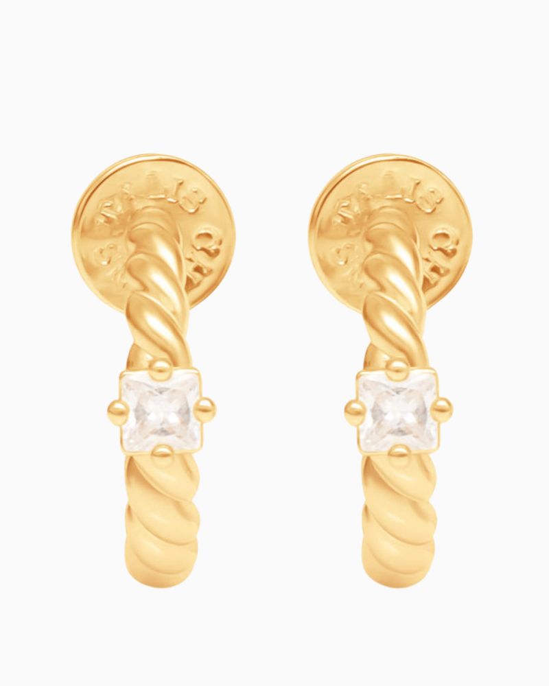 Close-up of twisted gold hoop earrings featuring small cubic zirconia stone