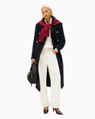 Model wearing white jeans with tucked-in tee and trainers