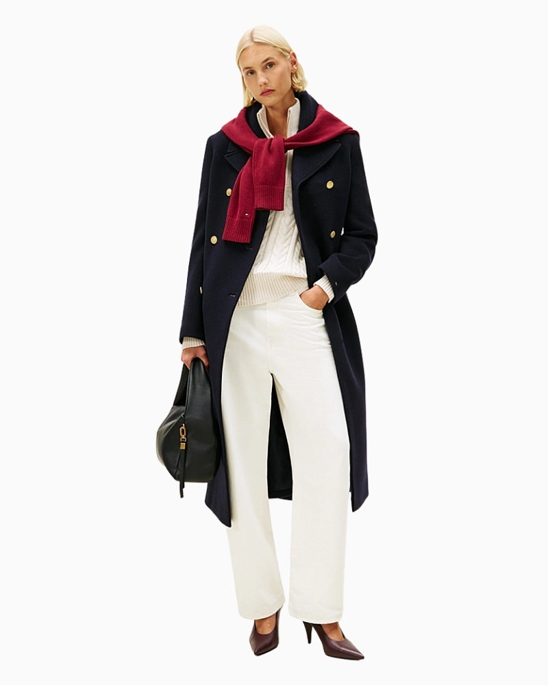 Model wearing white jeans with tucked-in tee and trainers