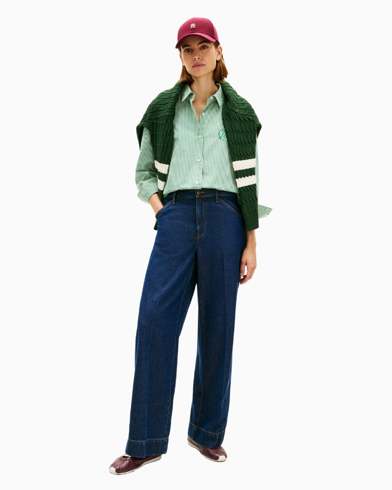 Model styling green shirt with white trousers and flats