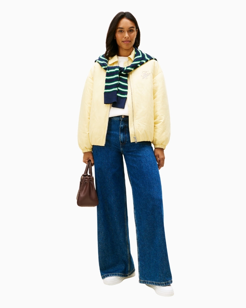 Model wearing high-rise wide leg jeans with a tucked-in blouse