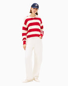 Model wearing red rugby-style jumper with jeans