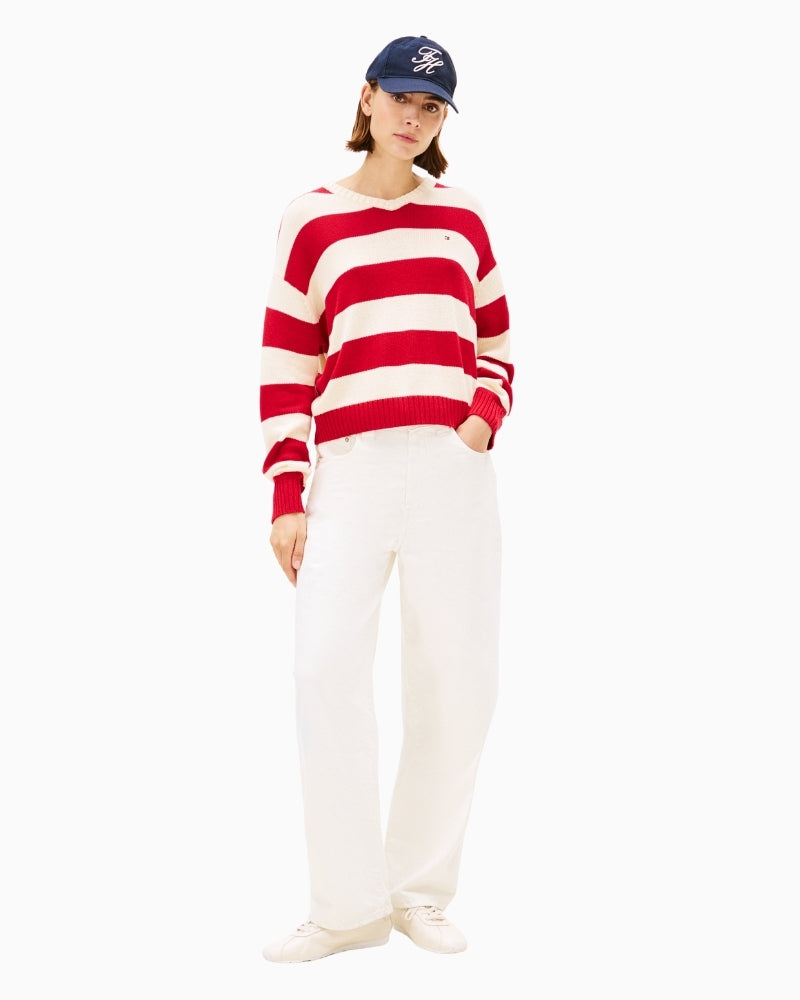 Model wearing red rugby-style jumper with jeans