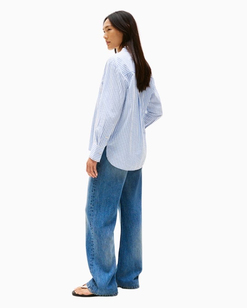 Back of Feminine blue shirt styled with white jeans for a fresh summer look

