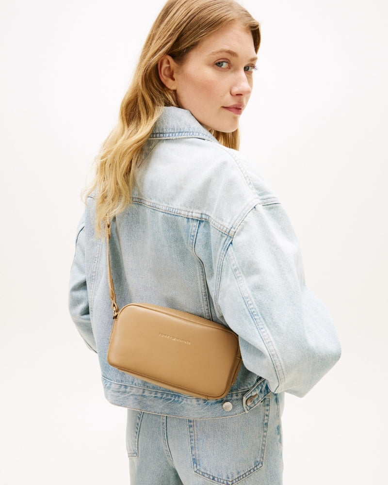 Woman wearing Tommy Hilfiger TH Essential camera bag beige – Áines Boutique