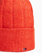 Close up view of bright orange Tommy beanie showing soft texture and snug fit
