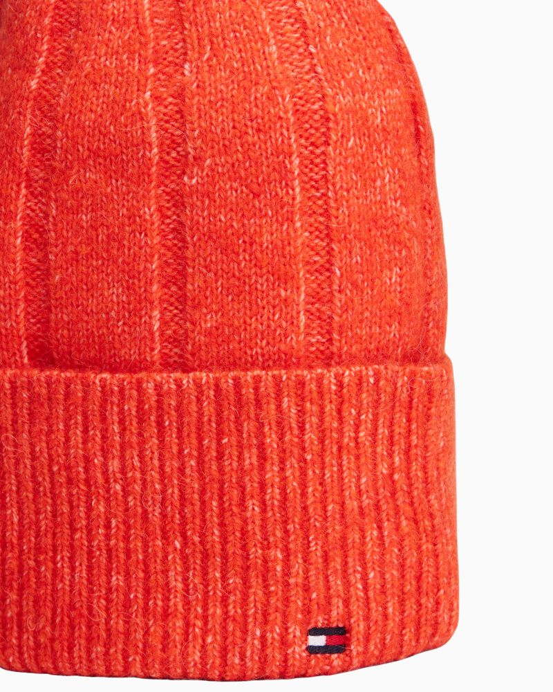 Close up view of bright orange Tommy beanie showing soft texture and snug fit