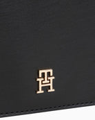 Close up view of TH Icon chain bag in faux leather showing flap closure and structured shape
