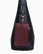 Side view of navy faux leather tote with all-over logo detail