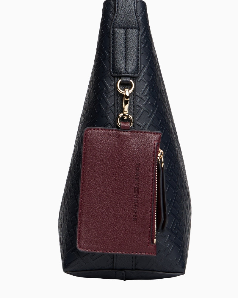 Side view of navy faux leather tote with all-over logo detail