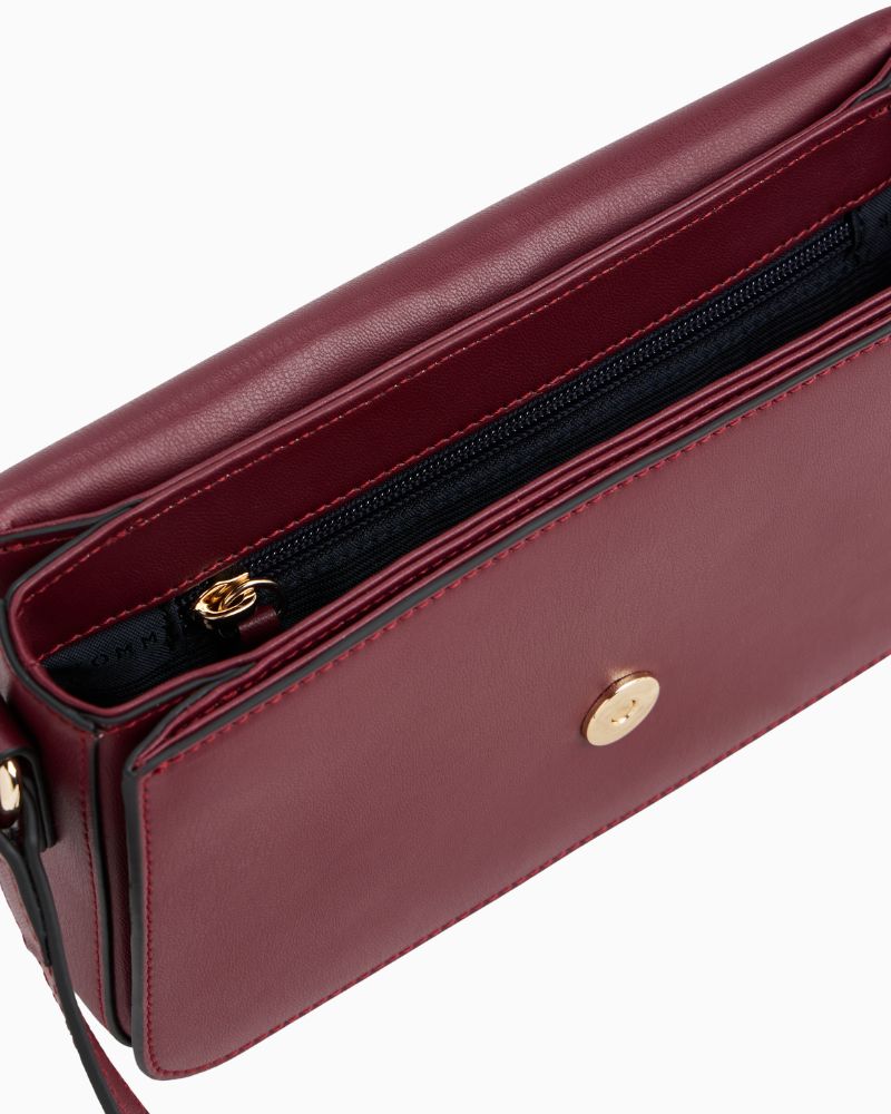 Side view of Tommy Hilfiger compact crossbody in structured red finish with flap closure