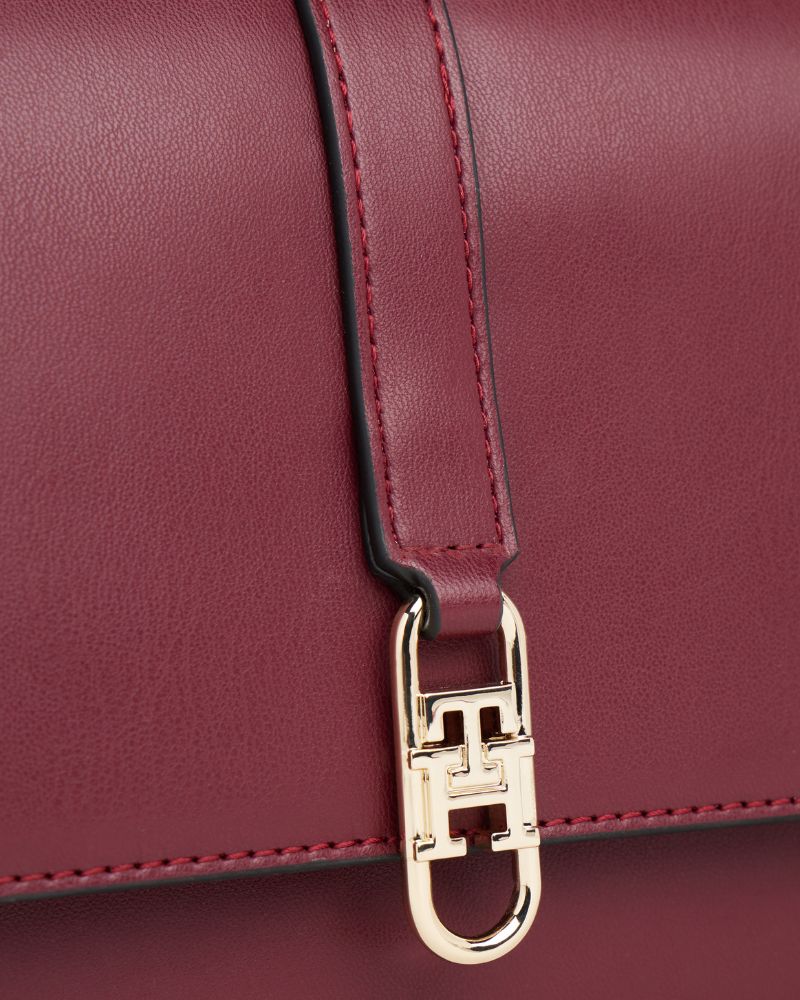 Close up view of Tommy Hilfiger compact crossbody in structured red finish with flap closure