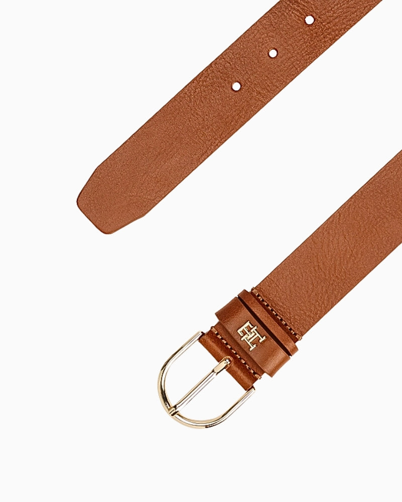 Close-up of tan Tommy Hilfiger belt showing curved gold buckle and adjustable strap