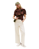 Model wearing white jeans and stripe shirt paired with Tommy Hilfiger White Trainers