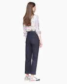 Side angle of dark denim trousers showing fixed cuff and slim straight cut